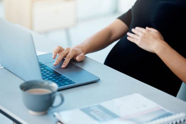 Pregnant woman working on laptop - Pregnancy Discrimination